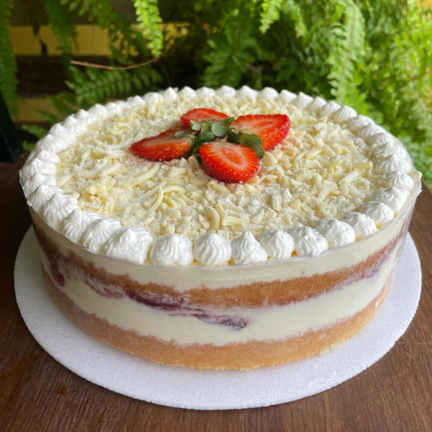 Naked cake com camadas expostas, chantilly, morangos e raspas de chocolate branco